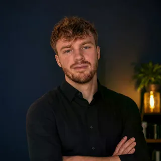 Philipp Steglich, Porträt in dunklem Hemd vor dunkelblauem Hintergrund